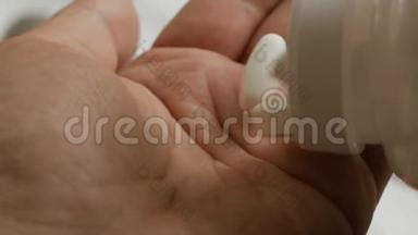 手掌上握着各种白色药丸的特写。 人手拿药丸，维生素或药物药片..